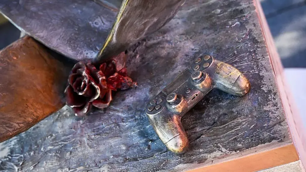 A flower and PlayStation controller on the memorial in honour of Diogo Jota and Andre Silva